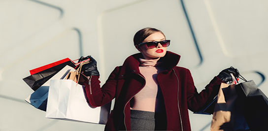 تصویر زنی با عینک آفتابی و کیسه های خرید لباس